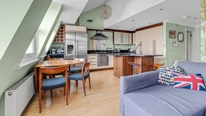 Una cocina moderna con comedor, sofá y una lámpara de araña.