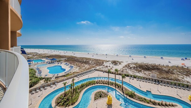 A resort with a pool area, beach access, and a clear view of the ocean.