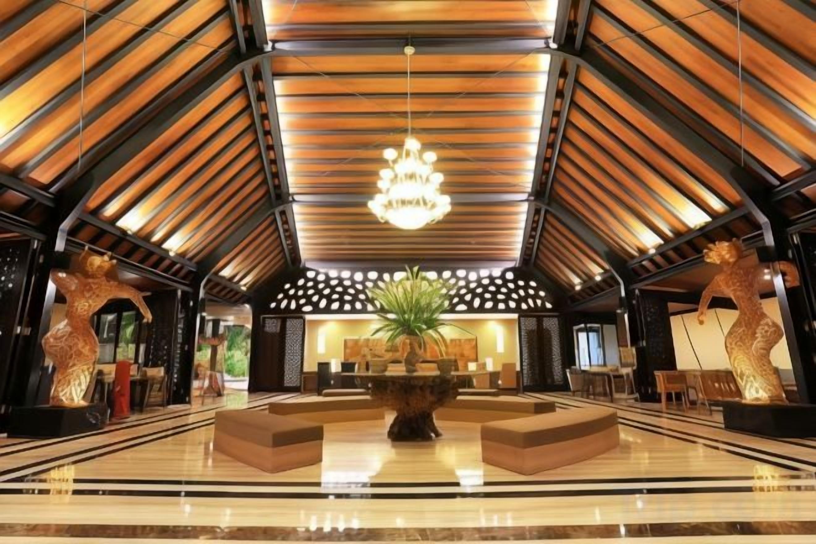 A spacious lobby with a high ceiling, a central fountain, and a reception desk.