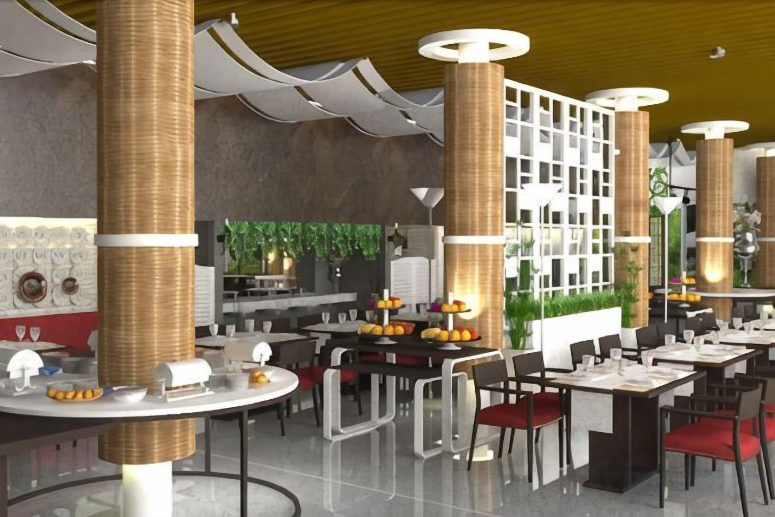 A restaurant with round tables, chairs, and a central white column with plants.