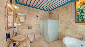 Un baño con bañera, ducha, lavamanos e inodoro.