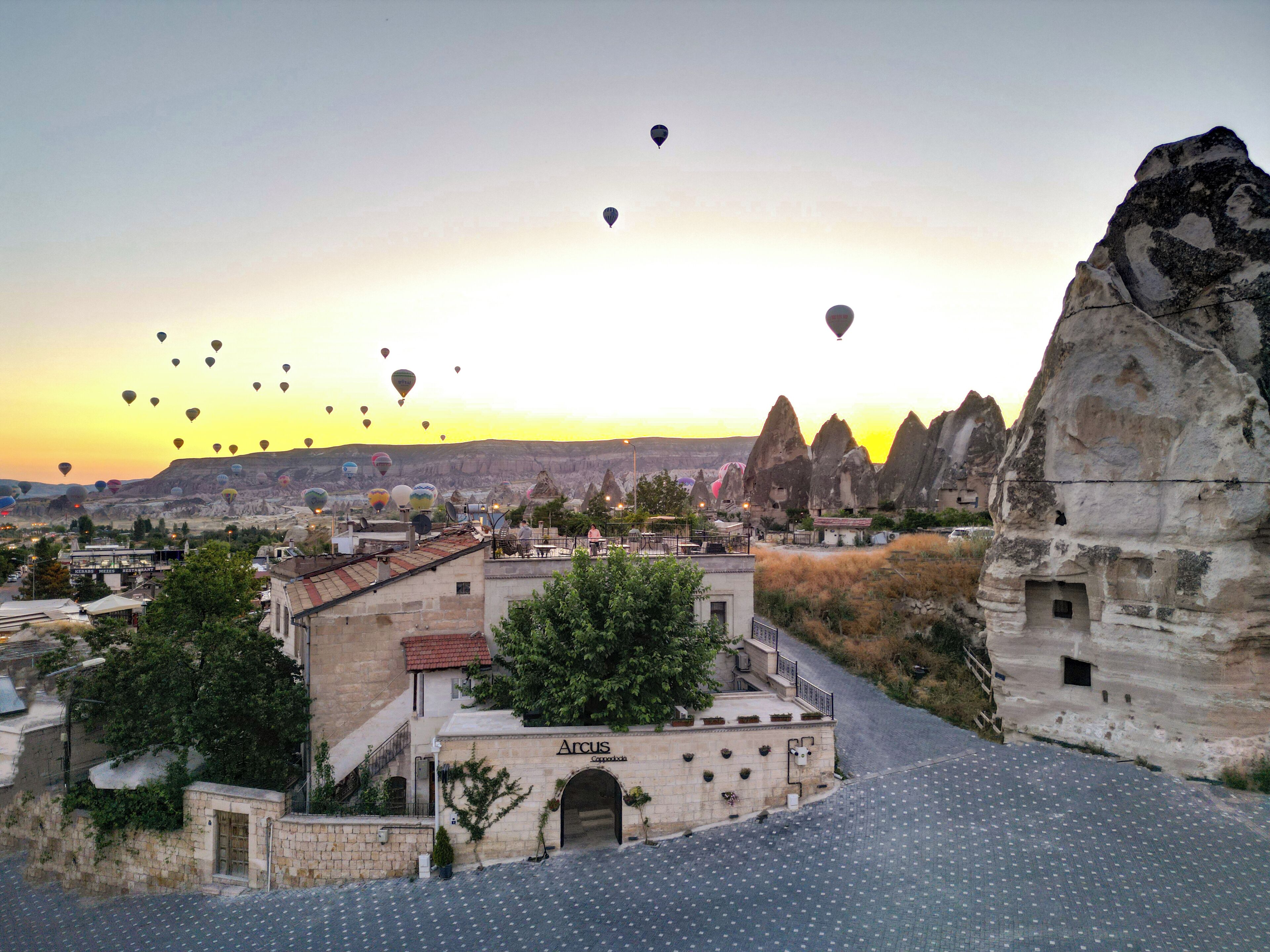 Vue d’une ville avec une formation rocheuse imposante et un bâtiment portant l’inscription « Arcus ».