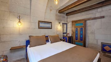 Un dormitorio con cama, dos lámparas de pared, un armario de madera y un espejo decorativo.