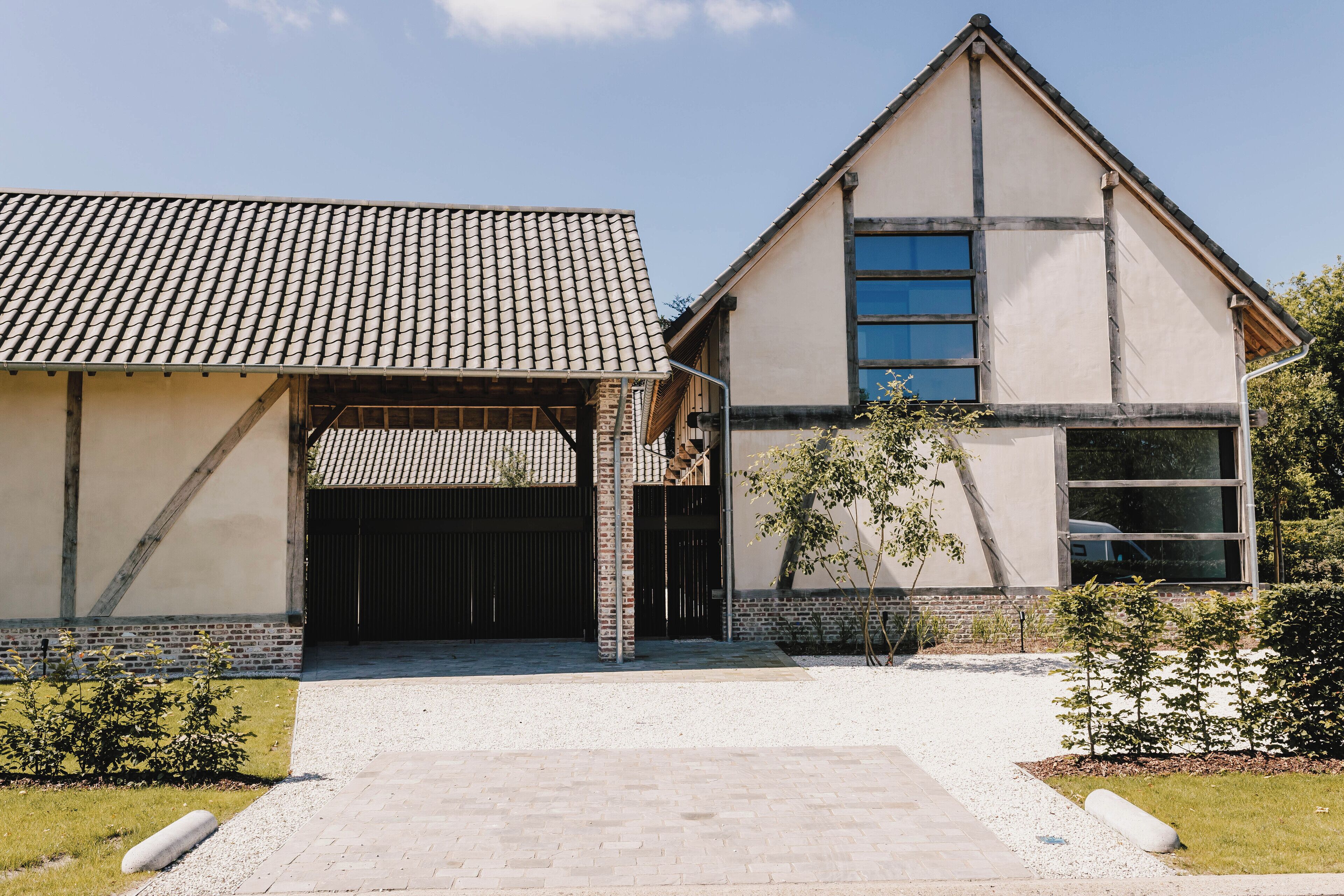 A modern building with a tiled roof, a large garage door, and a well-maintained lawn.