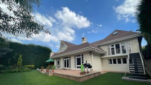 A two-story house with a covered patio, a barbecue grill, and a staircase leading to an upper level. - Colonial House, beautifull spacious garden house  (La Paz)