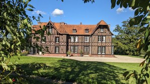 Un edifici gran i tradicional d'estructura de fusta i rajola, amb una façana simètrica, nombroses finestres i un pràctic jardí davant.