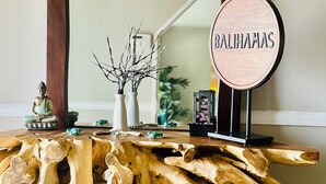 A wooden table with a sign that reads "BaliHamas" and a Buddha statue.