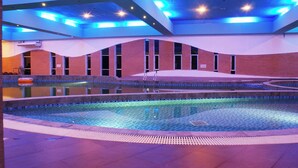 Una piscina interior con suelo de baldosas y diseño de pared curva.