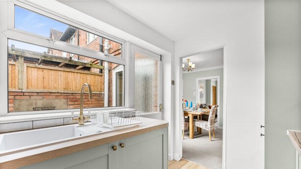 A modern kitchen with a large window, a sink, and a wooden countertop. - Perfect Home near Cotswolds (Worcestershire)