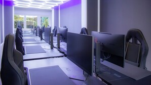 Un bureau moderne avec des rangées de bureaux et de chaises, chacun étant équipé d’un écran d’ordinateur.