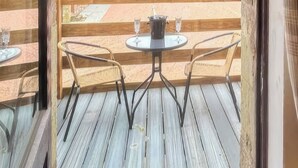 A wooden deck with a table and two chairs.