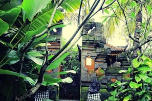 A traditional Balinese temple with intricate carvings and a staircase leading to the entrance. - Ubud Hotel & Cottages (Sukun)