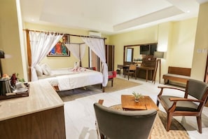 Una habitación de hotel con cama, escritorio, silla y televisión.