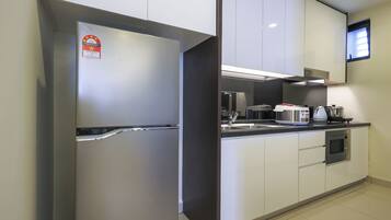 A modern kitchen with stainless steel appliances, white cabinets, and a built-in microwave.