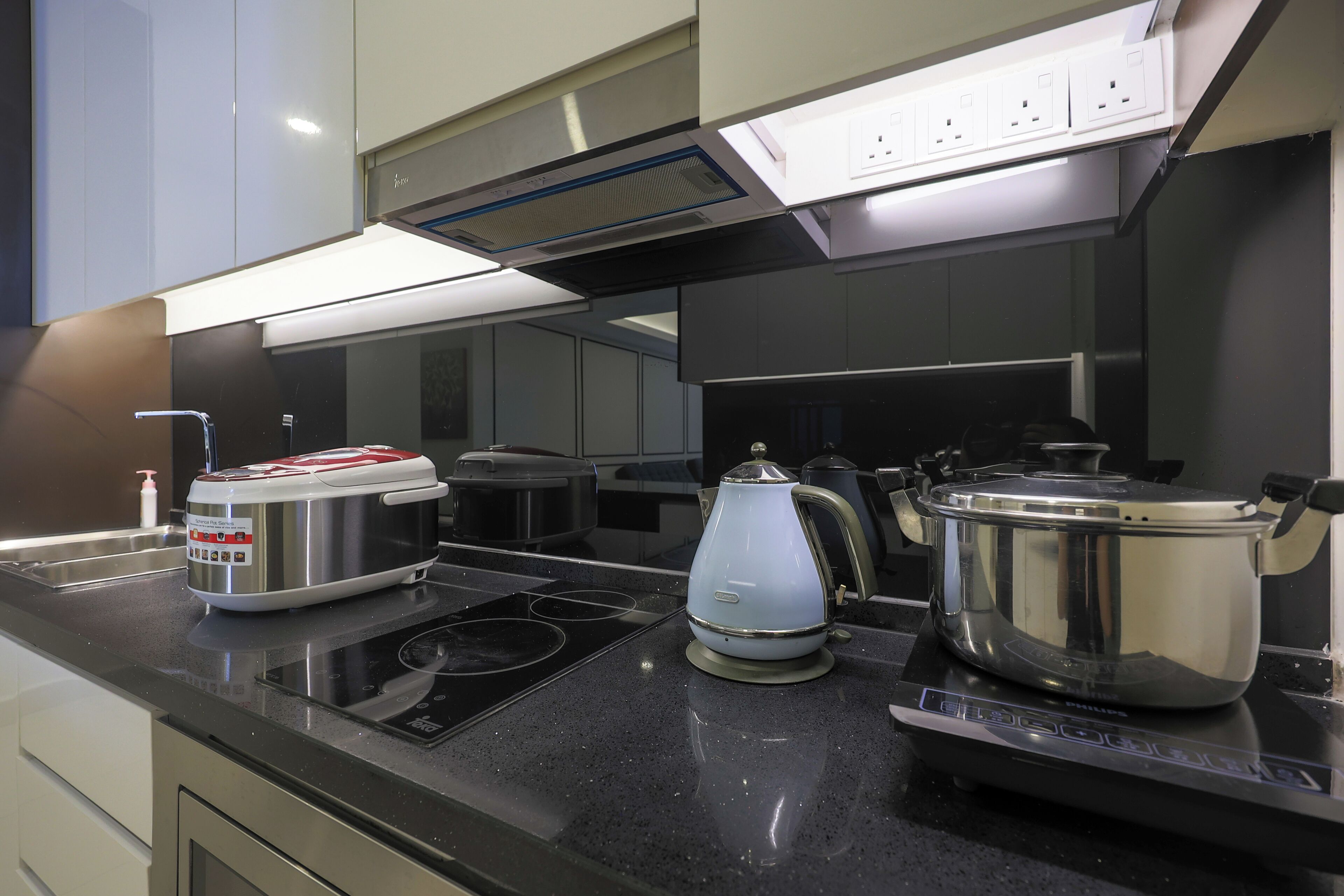 A modern kitchen with stainless steel appliances, a built-in oven, and a range hood.