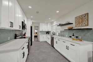 A modern kitchen with white cabinets, a microwave, and a sink. - Walk to Whitewater Amphitheater-GameRoom & Firepit (Canyon Lake)