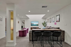 A modern interior with a bar area, seating, and artwork on the walls.