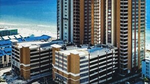 A high-rise hotel with multiple floors, a beach view, and a parking area. - Brand New Phoenix Gulf Tower 2507 /Lazy River/Beach
Your Vacation Getaway! (Orange Beach)