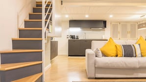 A modern apartment with a staircase, a kitchen, and a living area with a sofa and cushions. - Heart Milan Apartments Duomo Missori (Milan)