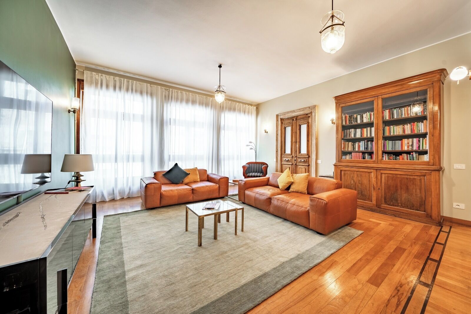 A living room with a sofa, coffee table, and a bookshelf.