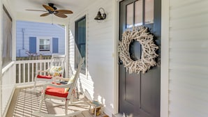 A porch with white rocking chairs, a ceiling fan, and a wreath on the door. - Fall Fun Near Potomac River & Colonial Beach (Colonial Beach)