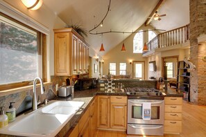 Una cocina amplia con armarios de madera, una isla grande y electrodomésticos modernos.