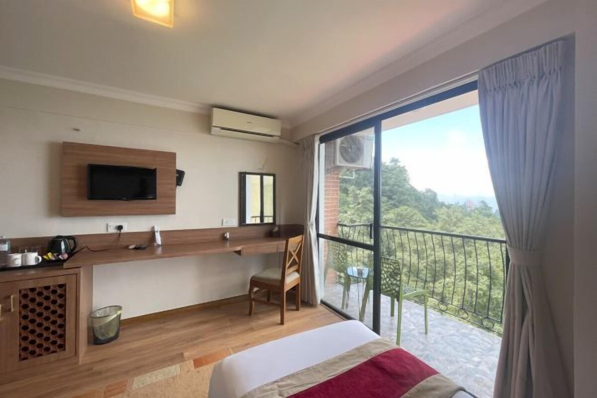 Une chambre d’hôtel avec un lit, un bureau, une télévision et un balcon offrant une vue.