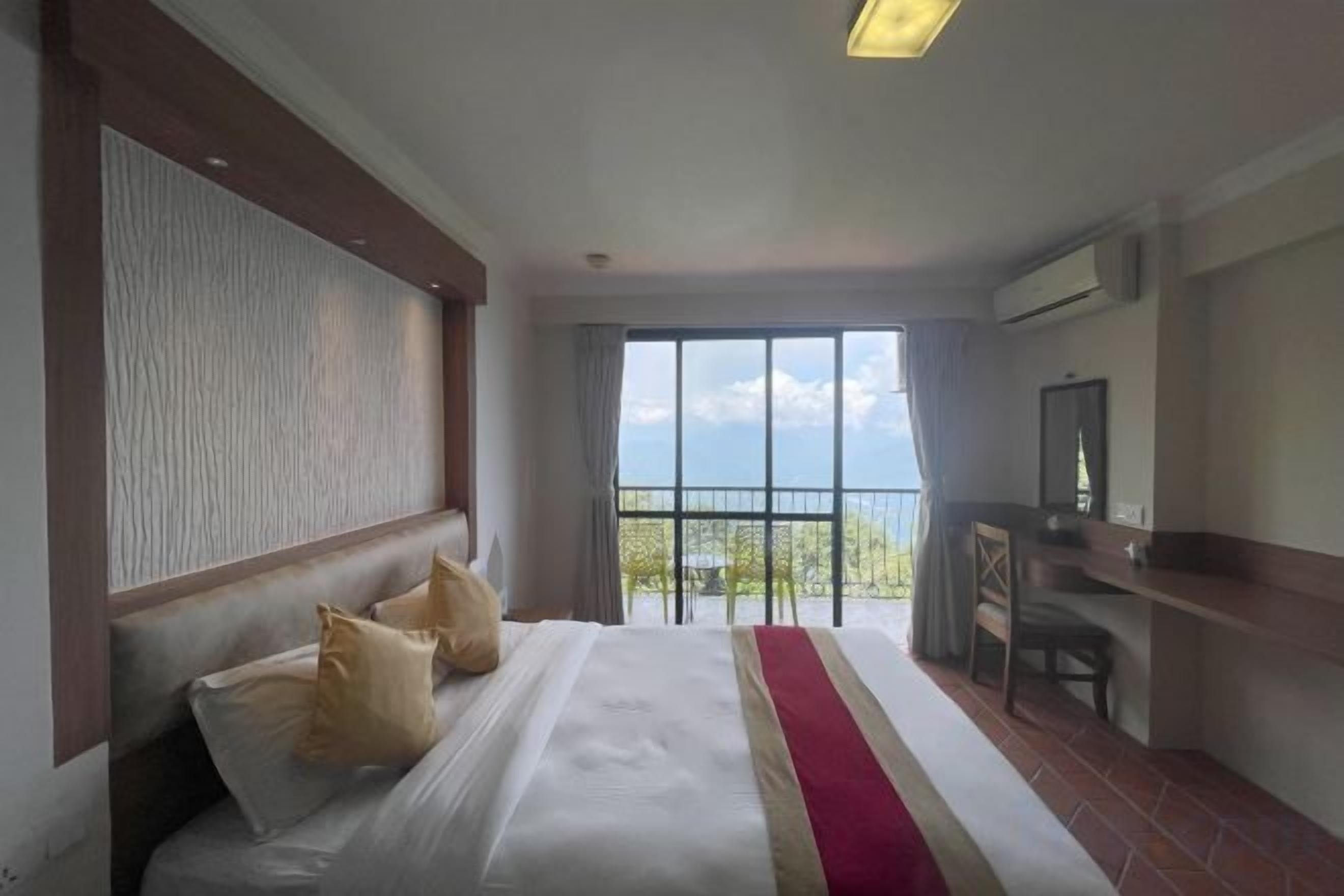Habitación de hotel con una cama grande, un escritorio y vistas al exterior.