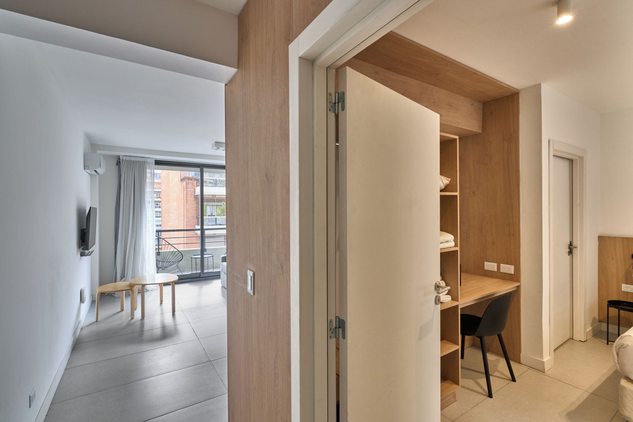 Un apartamento moderno con balcón, comedor y espacio para trabajar.