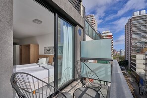 A modern hotel room with a balcony, a bed, and a seating area. - Alma Rentals French Palermo (Buenos Aires)