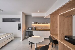 A modern kitchen with a dining area, a built-in oven, and a coffee machine. - Alma Rentals French Palermo (Buenos Aires)