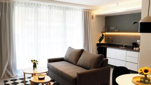 A modern living room with a sofa, a small table with a vase of flowers, and a checkered rug. - Alma Rentals French Palermo (Buenos Aires)