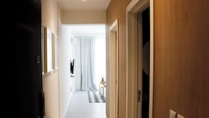 A hallway with a black door on the left, a white door on the right, and a checkered floor. - Alma Rentals French Palermo (Buenos Aires)