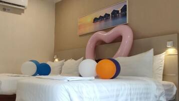 A hotel room with a bed, pillows, and a large abstract art piece on the wall.