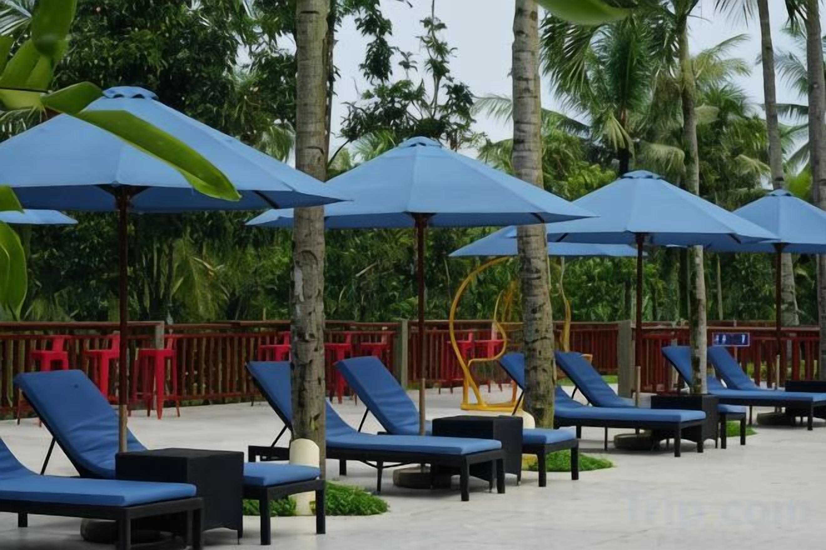 A poolside area with lounge chairs and umbrellas.