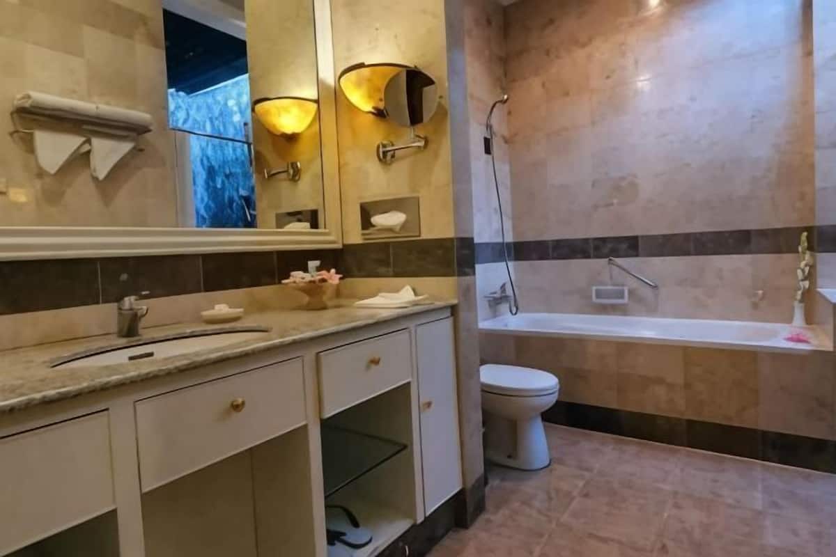A bathroom with a bathtub, toilet, and vanity with drawers.