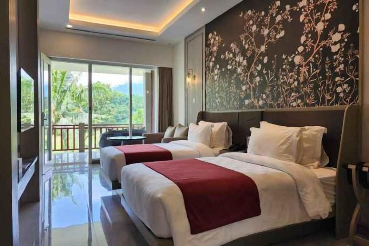 A hotel room with two beds, a large window with a view, and a decorative wall.