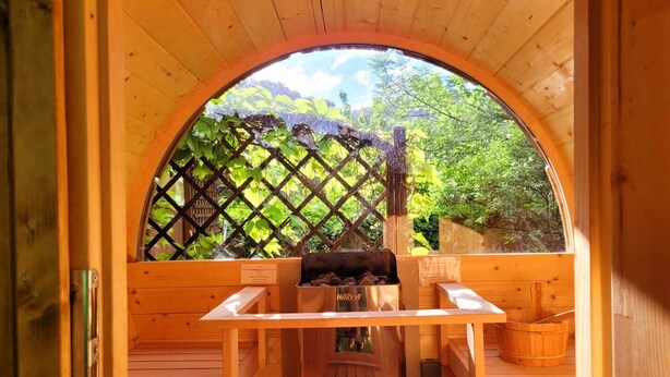 A wooden sauna with a bench, a table, and a Harvia sauna heater.