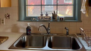 A kitchen with a double sink, a window with a floral valance, and a 'S.O.S. Smoking' sign. - Cozy & Spacious 2Bed, 2Bath in the heart of Winfield (Winfield)