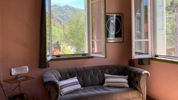A room with a sofa, a radiator, and a window with an open shutter. - Studio (2 people) (SAHORRE)