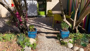 A courtyard with a tiled floor, potted plants, and outdoor seating. - Studio (3 people) (SAHORRE)
