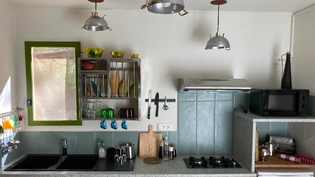 A kitchen with a sink, stove, microwave, and hanging lights. - Studio (3 people) (SAHORRE)