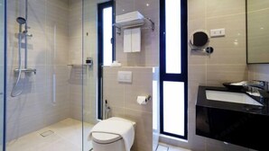A modern bathroom with a glass shower enclosure, a toilet, a sink, and a mirror. - Hutton Central Hotel Managed By The Ascott Limited  (George Town)