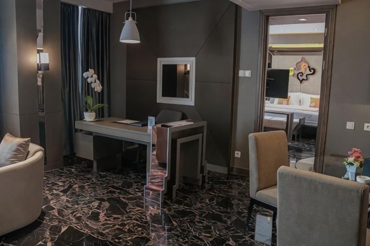 Una habitación de hotel con escritorio, silla y comedor.