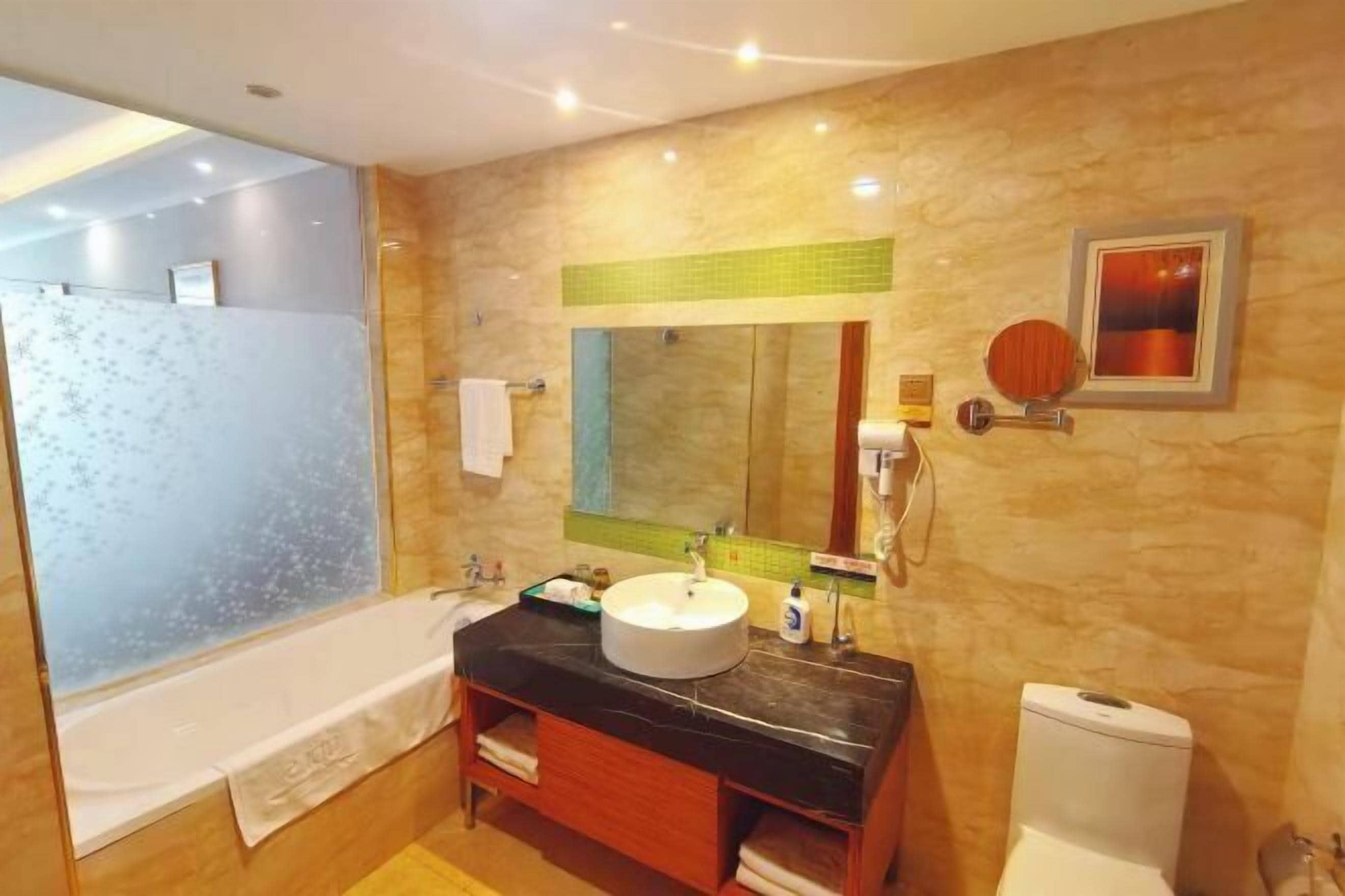 A bathroom with a bathtub, a sink, a toilet, and a mirror.