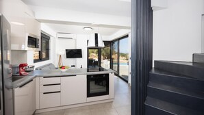 A modern kitchen with a built-in oven, a microwave, and a dining area with a view of the outdoors.