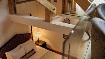 A bedroom with a bed, nightstand, and a mirror.