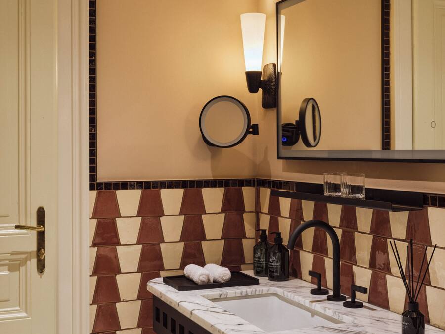 Une salle de bain équipée d’un lavabo, d’un miroir, d’un porte-serviettes et d’articles de toilette.