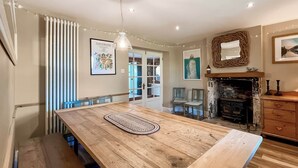 A dining area with a wooden table, chairs, and a fireplace.