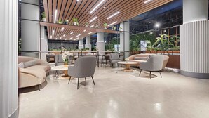 A modern lounge area with a curved sofa, round tables, and chairs, featuring a wooden ceiling and indoor plants. - Silkhaus Safa 47 A (Riyadh)